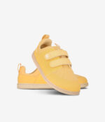 Lysegule barfodssneakers til børn med velcroremme, hvide såler, bred tåboks og minimalistisk design på hvid baggrund.
