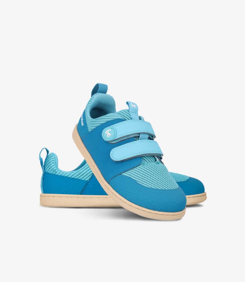 Blå barfodssneakers til børn med overdel i let mesh, bred tåboks, velcroremme og fleksible, solbrune såler på hvid baggrund.