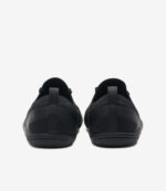 Sorte Xero Nexus Knit barfodssko til mænd, bred tåboks, minimalistiske sneakers med hælkappe og tekstureret sål, set bagfra.