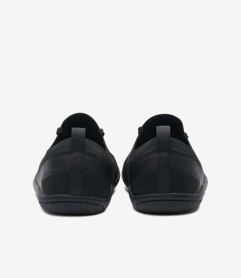 Sorte Xero Nexus Knit barfodssko til mænd, bred tåboks, minimalistiske sneakers med hælkappe og tekstureret sål, set bagfra.