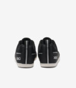 Sorte og hvide Xero Prio børn barfodssneakers, minimalistisk stil, bred tåboks, grå stribe og XERO-logo på hælen.