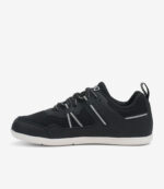 Sort og hvid barfodssko til børn, overdel i mesh, bred tåboks, minimalistisk sneaker-stil med perforerede sider på hvid baggrund.