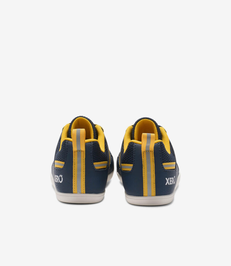Bagside af Xero Prio børn barfodssko i dress blues og spectra yellow med bred tåboks, hvide såler, fed XERO-hælbranding.