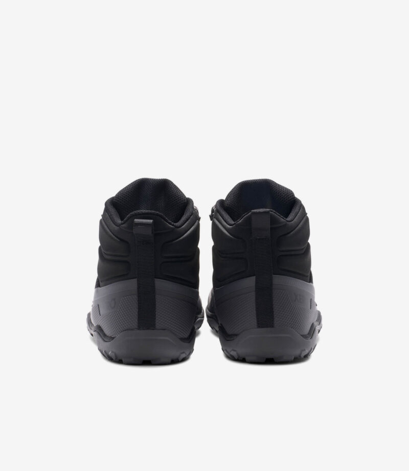 Sorte Xero Scrambler Trail Mid WP barfodssko, bred tåboks, robuste såler, minimalistisk design, vist bagfra på hvid.