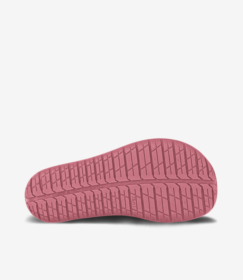 Pink gummisål på minimalistisk barfodssneaker med bred tåboks, der viser et gribevenligt mønster; ideel til naturlig bevægelse.