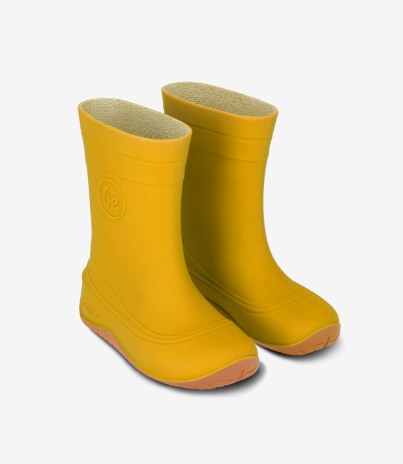 Gule minimalistiske barfodsregnstøvler med solbrune såler, bred tåboks, gummimateriale, side om side på en hvid baggrund.