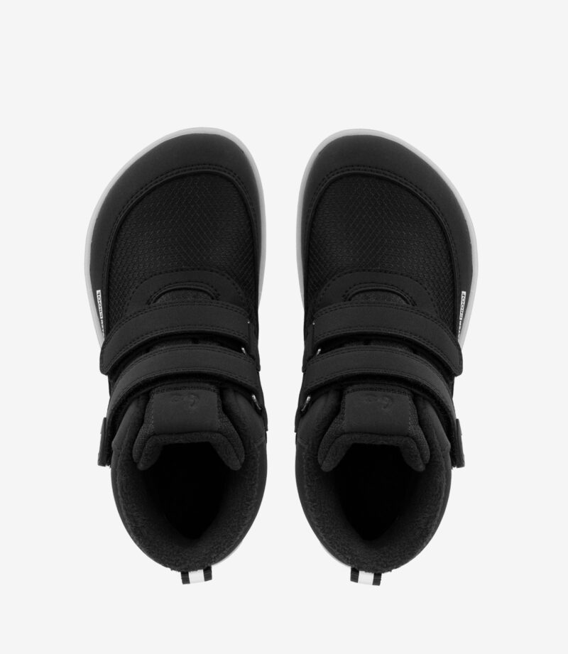 Sorte minimalistiske barfodssko til børn med bred tå, overdel i mesh, velcroremme og hvide såler på hvid baggrund.